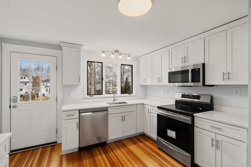 312 Edge Hill Road Milton, MA 02186 - Photo 5 of 19 a kitchen with stainless steel appliances granite countertop a stove a sink and a microwave