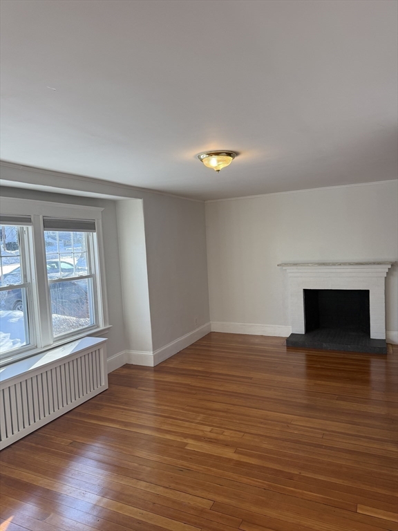 312 Edge Hill Road Milton, MA 02186 - Photo 5 of 13 an empty room with wooden floor and windows