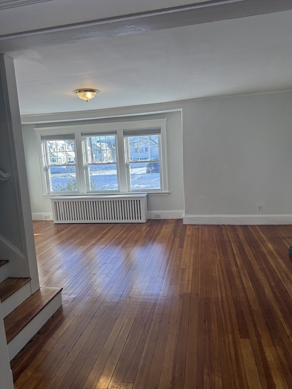 312 Edge Hill Road Milton, MA 02186 - Photo 6 of 13 a view of an empty room with wooden floor and a window