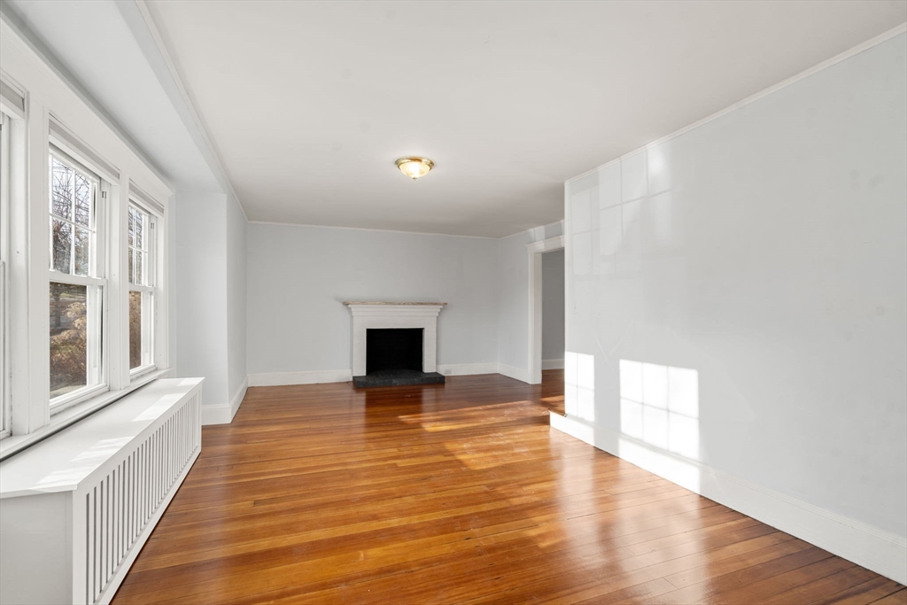 312 Edge Hill Road Milton, MA 02186 - Photo 9 of 19 a view of an empty room with wooden floor and a window