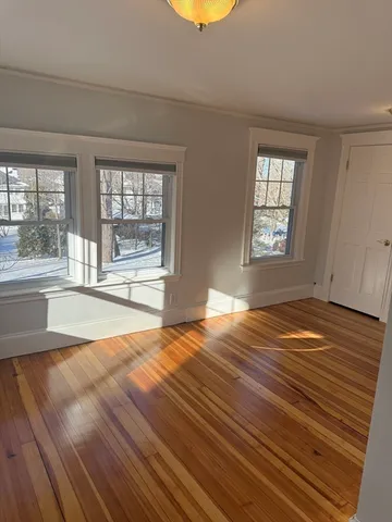 a view of a room with wooden floor and a window