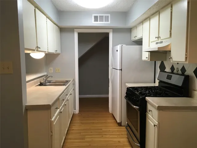 a kitchen with a sink stove and refrigerator