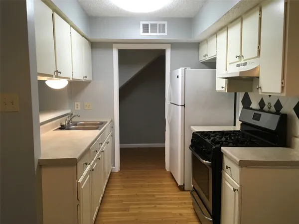 a kitchen with a sink stove and refrigerator