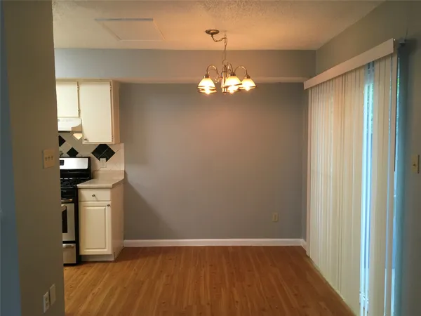 a view of a room with wooden floor and chandelier