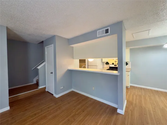 a view of empty room with wooden floor