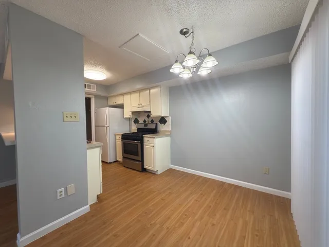 a view of a kitchen with a sink a refrigerator a ceiling fan and wooden floor
