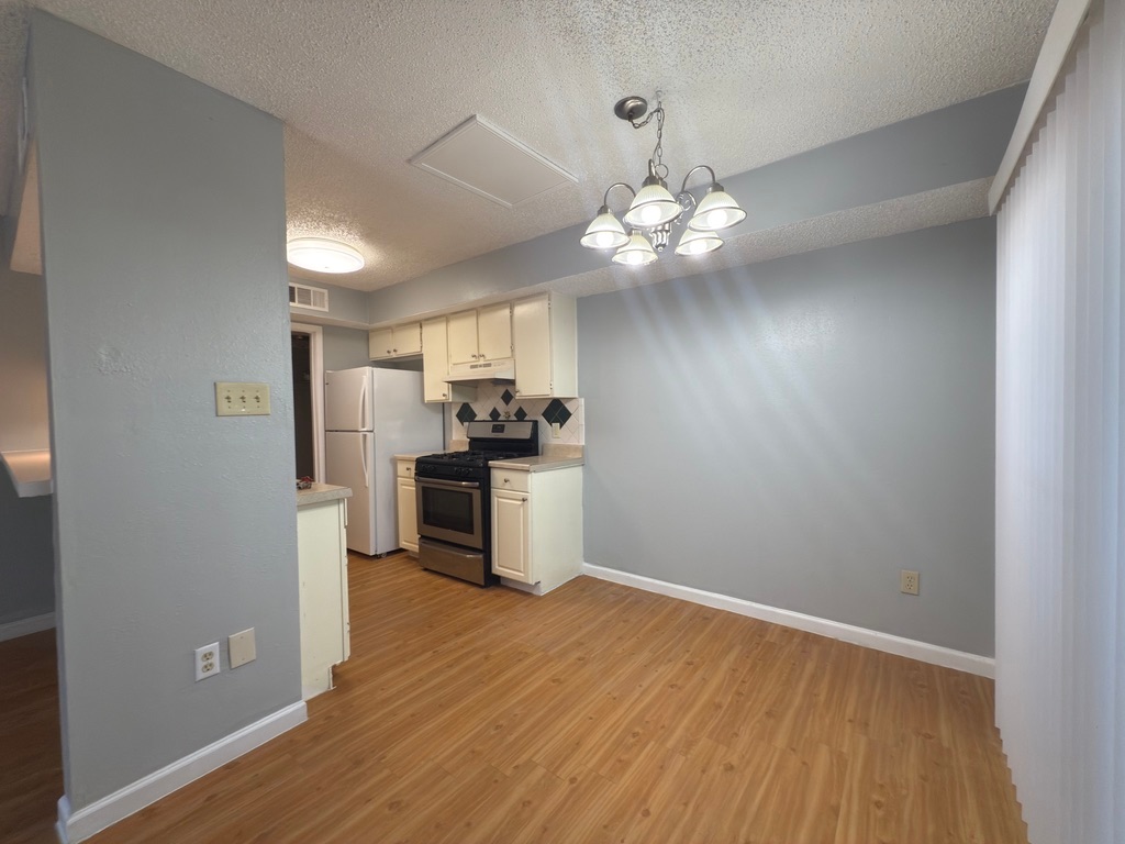 1312 Southport Drive, Unit B Austin, TX 78704 - Photo 8 of 15 a view of a kitchen with a sink a refrigerator a ceiling fan and wooden floor