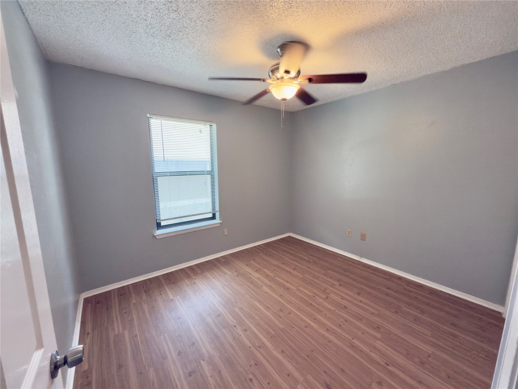 1312 Southport Drive, Unit B Austin, TX 78704 - Photo 10 of 15 an empty room with wooden floor fan and windows