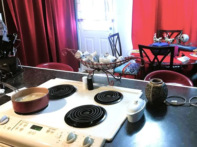 a kitchen with a stove and wooden floor