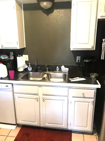 a kitchen with a sink cabinets and a wooden floor