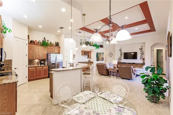 a kitchen with stainless steel appliances kitchen island granite countertop a stove a sink and a refrigerator