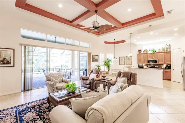 a living room with furniture and a large window with kitchen view
