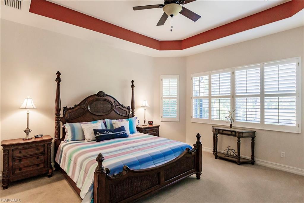 7684 Cottesmore Drive Naples, FL 34113 - Photo 28 of 46 a bedroom with a bed and a chandelier