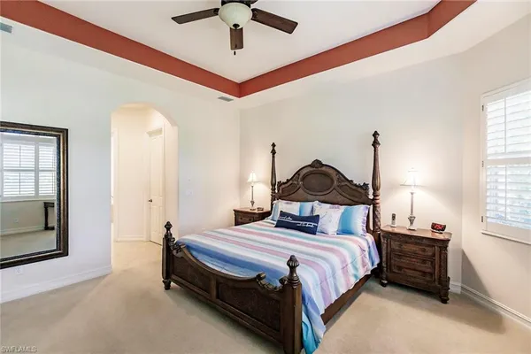 a bedroom with a bed ceiling fan and a window