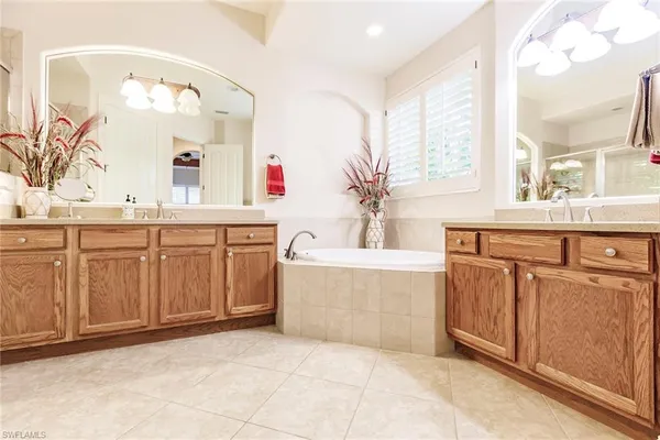 a spacious bathroom with a tub sink and mirror