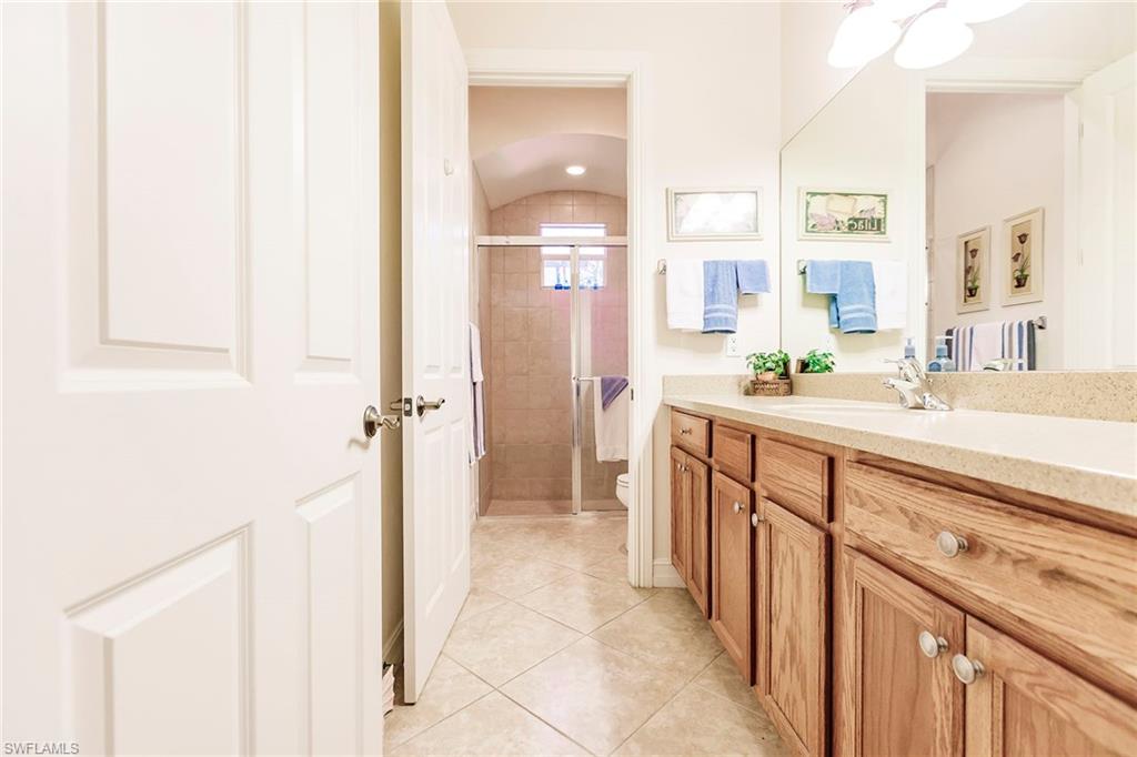 7684 Cottesmore Drive Naples, FL 34113 - Photo 36 of 46 a spacious bathroom with a double vanity sink a mirror and a shower