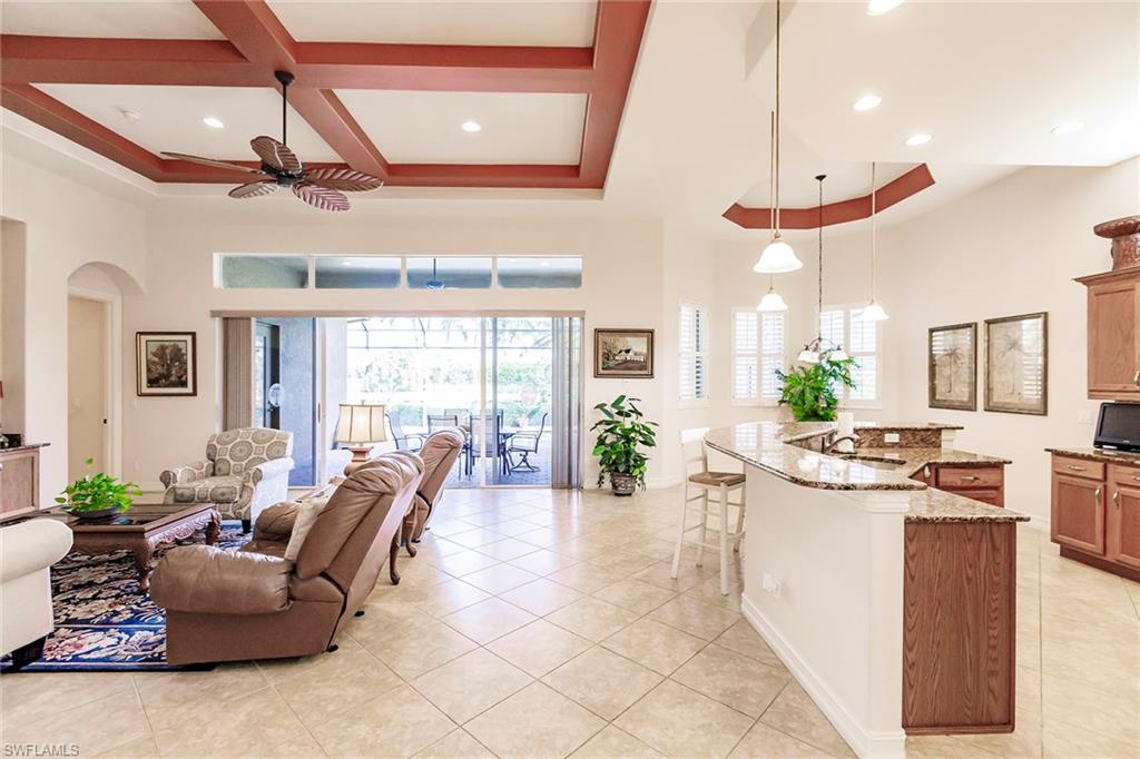 7684 Cottesmore Drive Naples, FL 34113 - Photo 10 of 46 a living room with furniture kitchen area and a chandelier