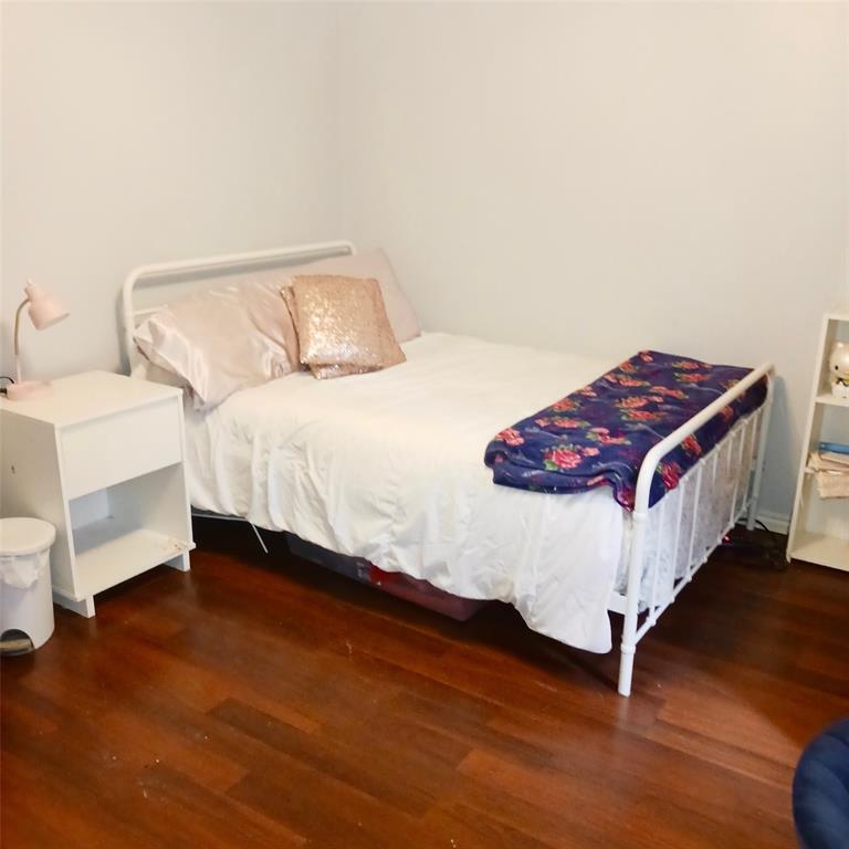 5750 Phoenix Drive, Unit 33 Dallas, TX 75231 - Photo 11 of 14 a bedroom with a bed and wooden floor
