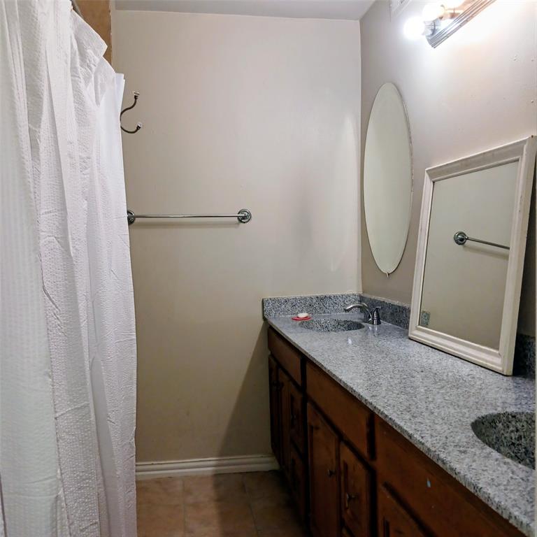5750 Phoenix Drive, Unit 33 Dallas, TX 75231 - Photo 14 of 14 a bathroom with a granite countertop sink and a mirror