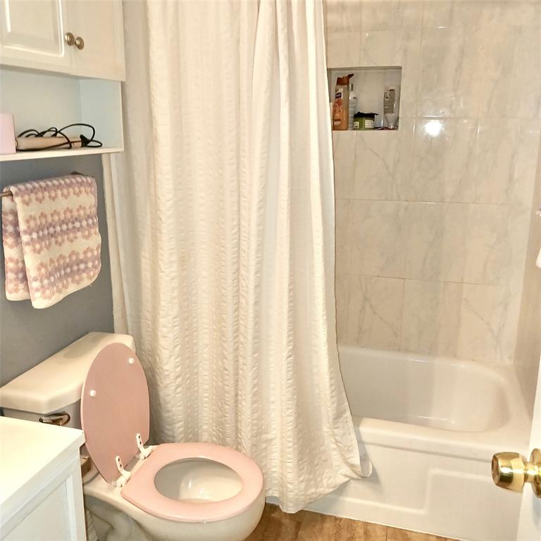 5750 Phoenix Drive, Unit 33 Dallas, TX 75231 - Photo 10 of 14 a bathroom with a toilet and a shower curtain