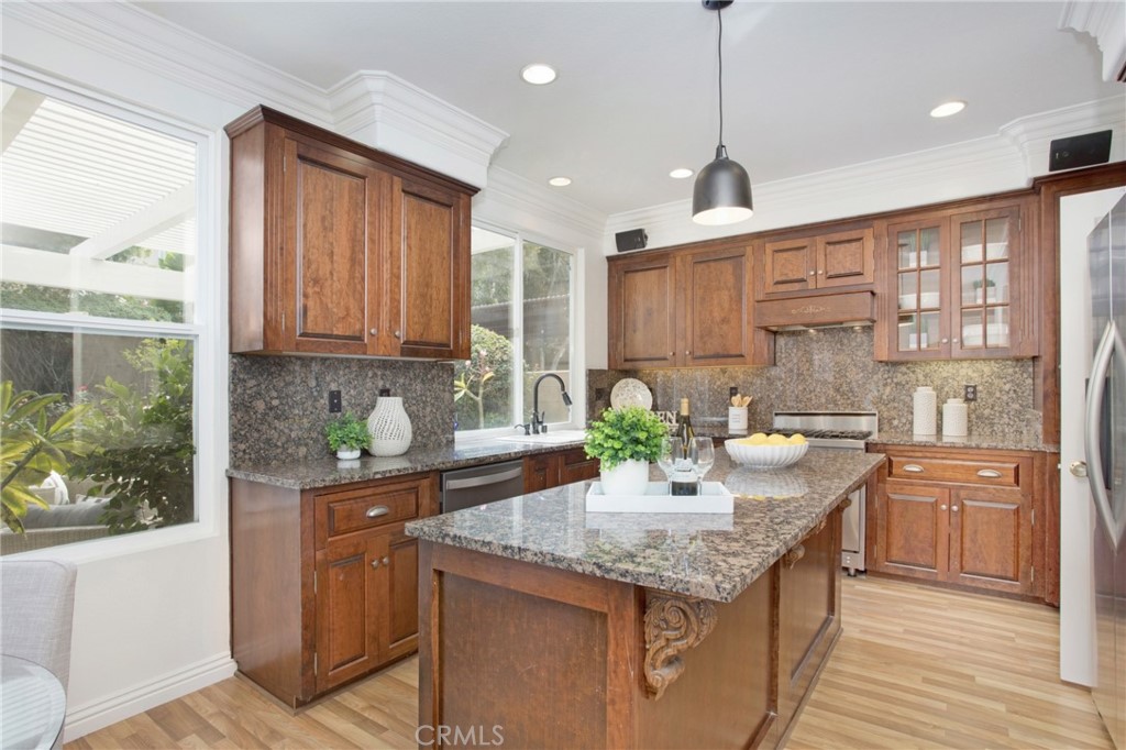 10 Bel Spring Irvine, CA 92602 - Photo 11 of 35 a kitchen with granite countertop kitchen island stainless steel appliances a sink stove and cabinets