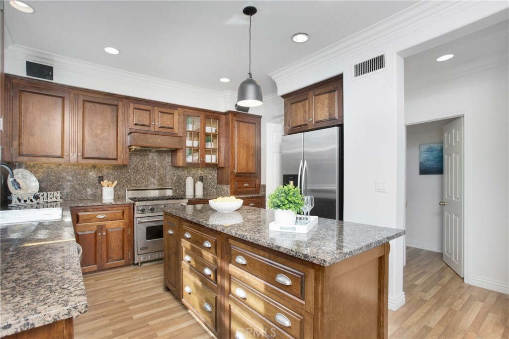 10 Bel Spring Irvine, CA 92602 - Photo 12 of 35 a kitchen with stainless steel appliances granite countertop stove top oven a refrigerator and dishwasher with wooden floor