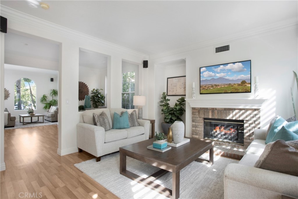 10 Bel Spring Irvine, CA 92602 - Photo 3 of 35 a living room with furniture a fireplace and a potted plant