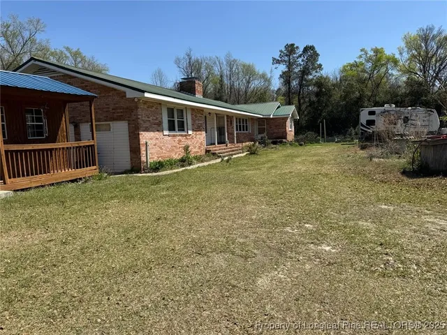 a view of a house with backyard and sitting area