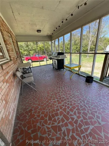 a view of a deck with chairs next to yard with wooden fence