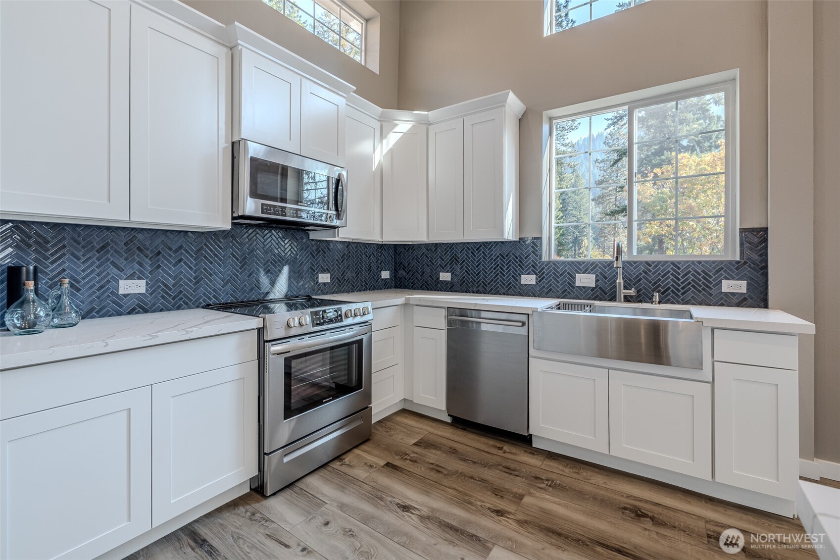 10642 Merry Canyon Road Leavenworth, WA 98826 - Photo 35 of 36 a kitchen with stainless steel appliances granite countertop white cabinets a sink a stove a microwave and a window
