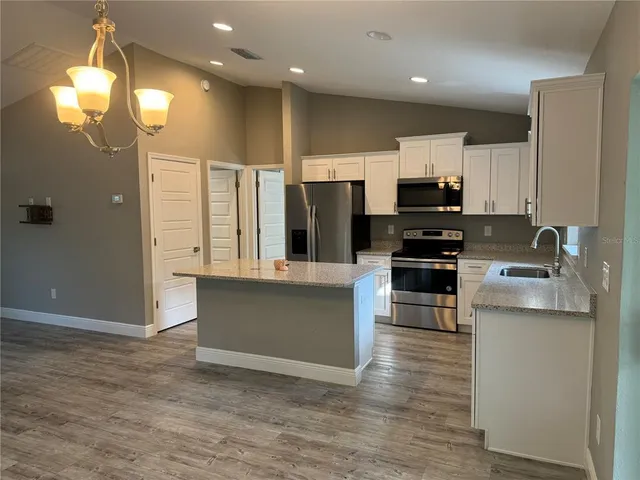 a kitchen with stainless steel appliances a refrigerator and a stove top oven