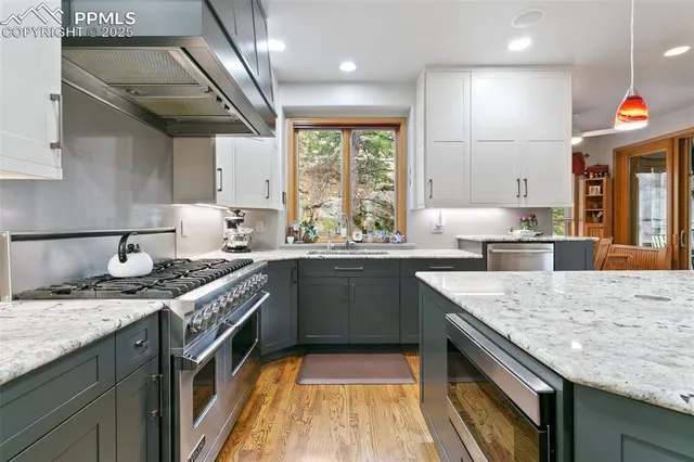 a kitchen with stainless steel appliances granite countertop a sink stove and cabinets