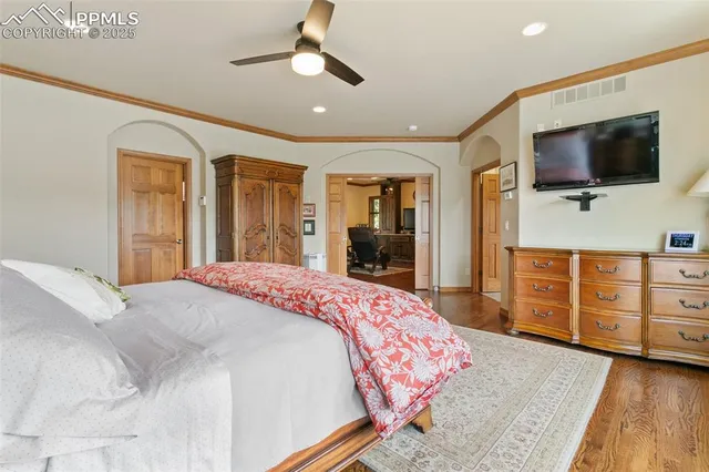 a spacious bedroom with a bed and a flat screen tv