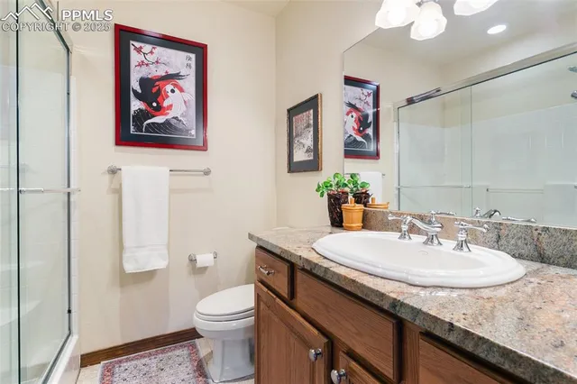 a bathroom with a granite countertop sink a toilet and a mirror
