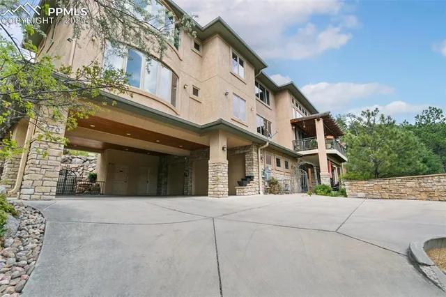 a view of a white building among the street with palm trees