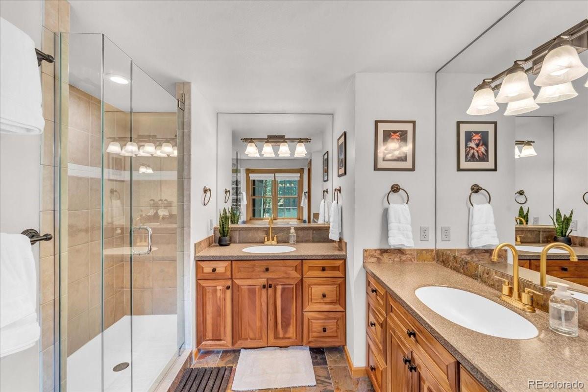 32217 Buffalo Park Road Evergreen, CO 80439 - Photo 13 of 46 a bathroom with double vanity sink and a mirror