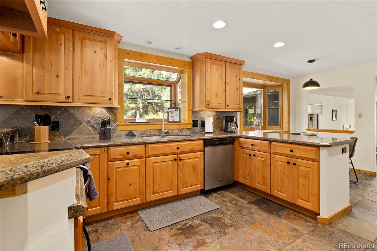 32217 Buffalo Park Road Evergreen, CO 80439 - Photo 20 of 46 a kitchen with stainless steel appliances granite countertop a stove a sink and a refrigerator