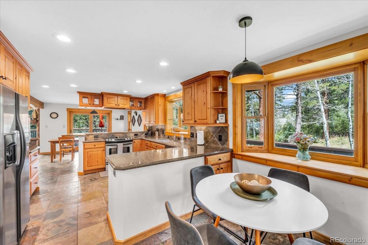 32217 Buffalo Park Road Evergreen, CO 80439 - Photo 21 of 46 a dining room with furniture a chandelier and a large window