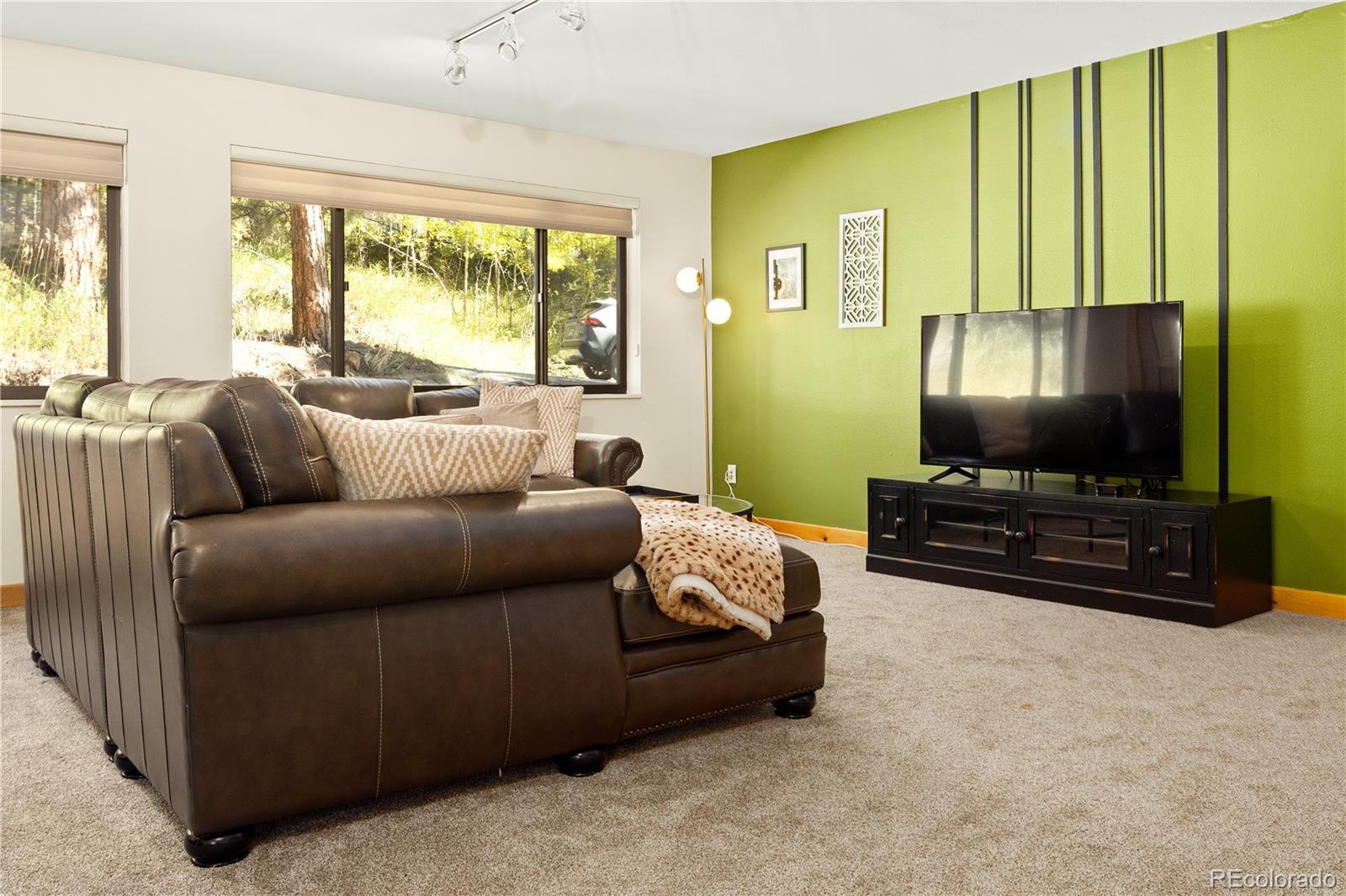 32217 Buffalo Park Road Evergreen, CO 80439 - Photo 22 of 46 a living room with furniture and a flat screen tv