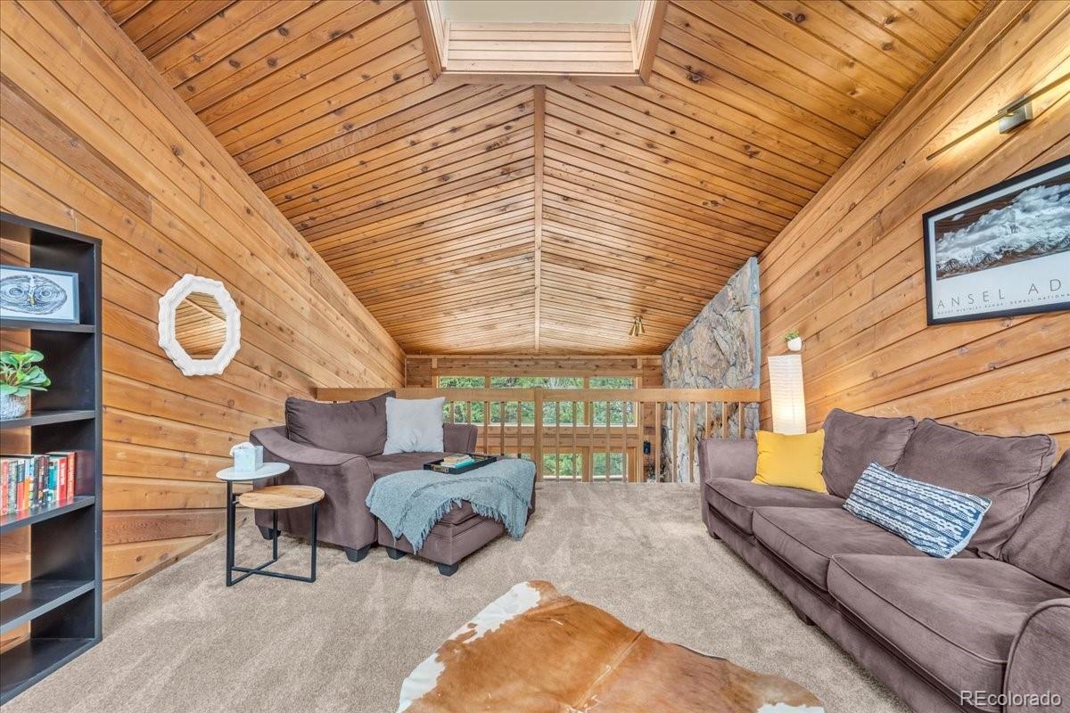 32217 Buffalo Park Road Evergreen, CO 80439 - Photo 24 of 46 a living room with furniture and a large window