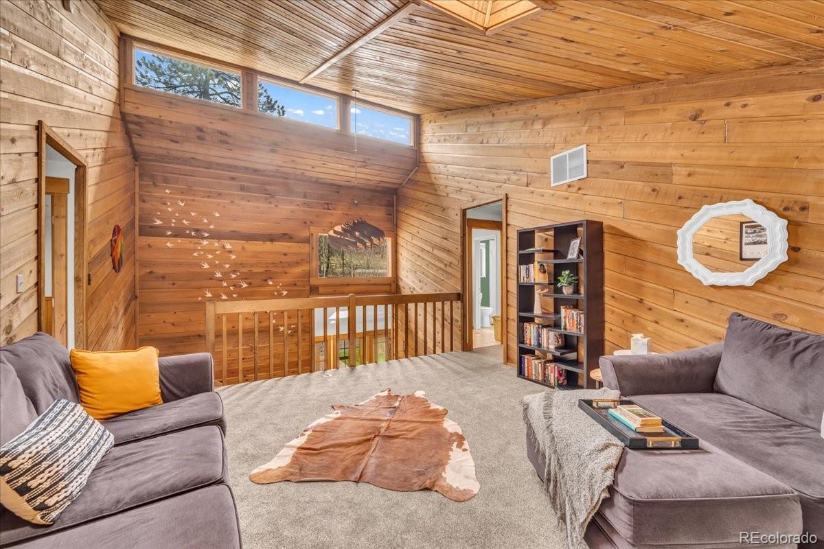 32217 Buffalo Park Road Evergreen, CO 80439 - Photo 28 of 46 a bedroom with furniture and a large window