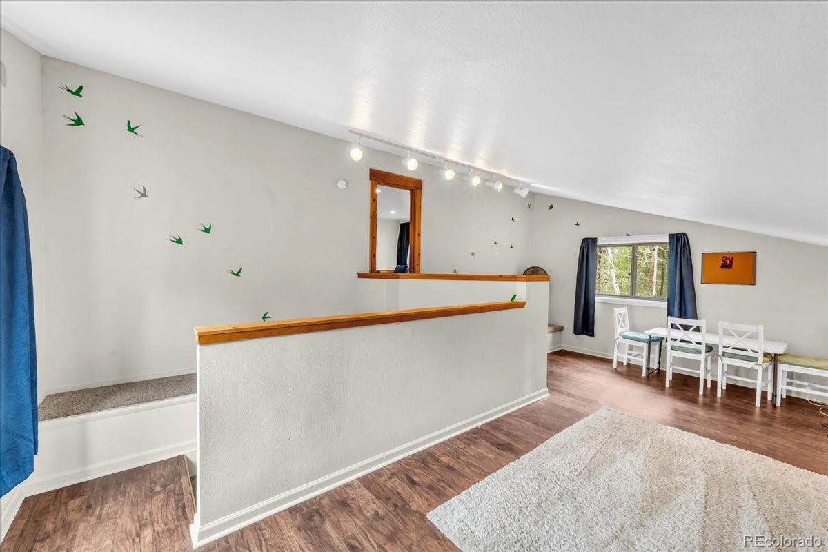 32217 Buffalo Park Road Evergreen, CO 80439 - Photo 31 of 46 a living room with furniture and a wooden floor
