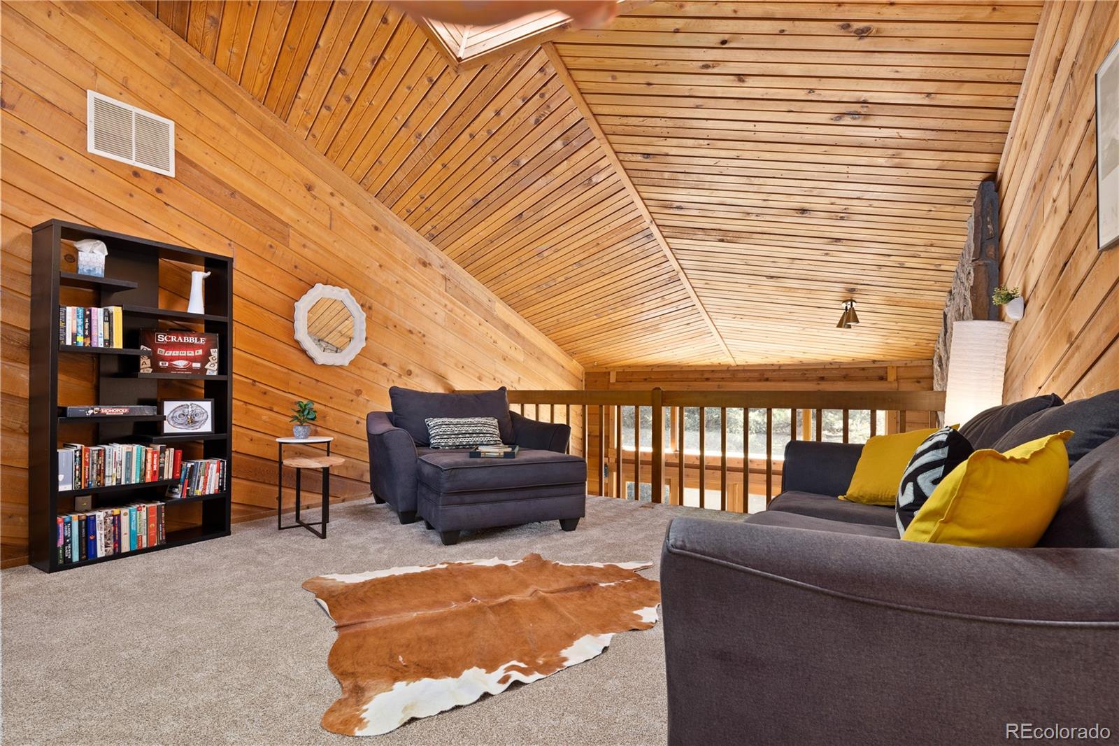 32217 Buffalo Park Road Evergreen, CO 80439 - Photo 39 of 46 a living room with furniture and a book shelf
