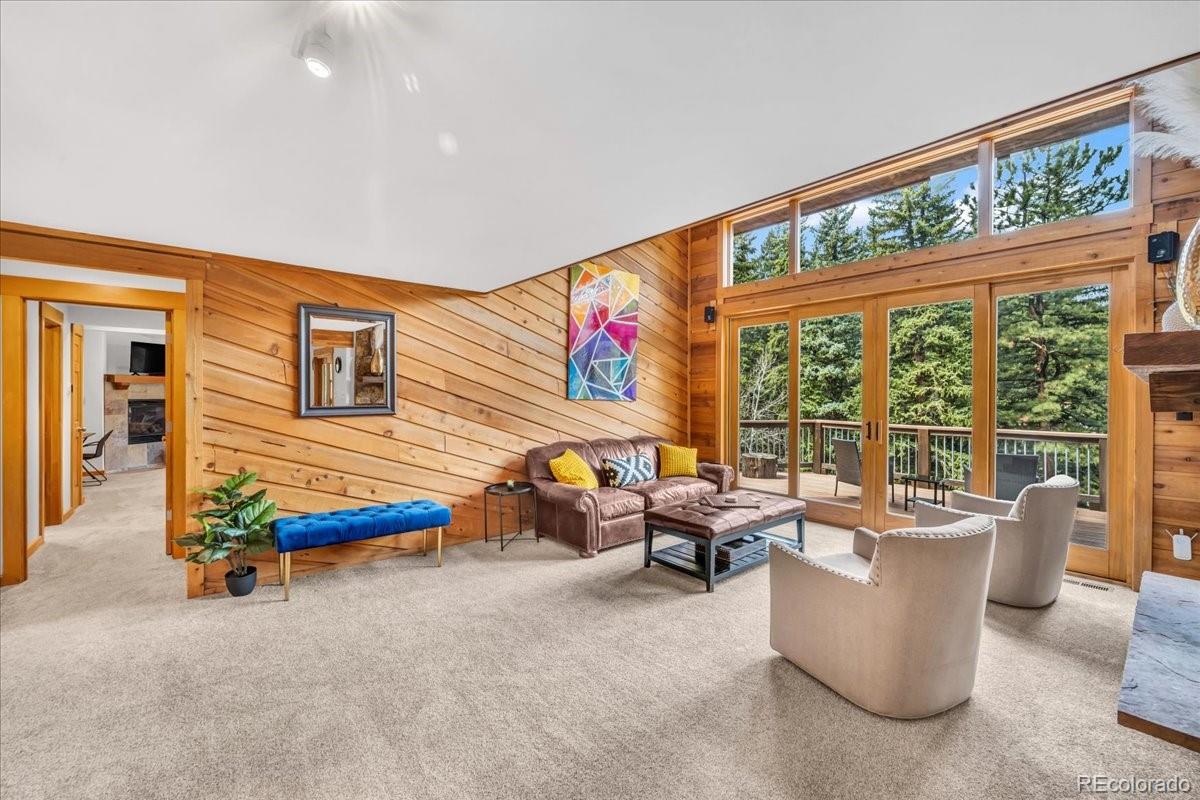 32217 Buffalo Park Road Evergreen, CO 80439 - Photo 8 of 46 a living room with furniture and floor to ceiling windows