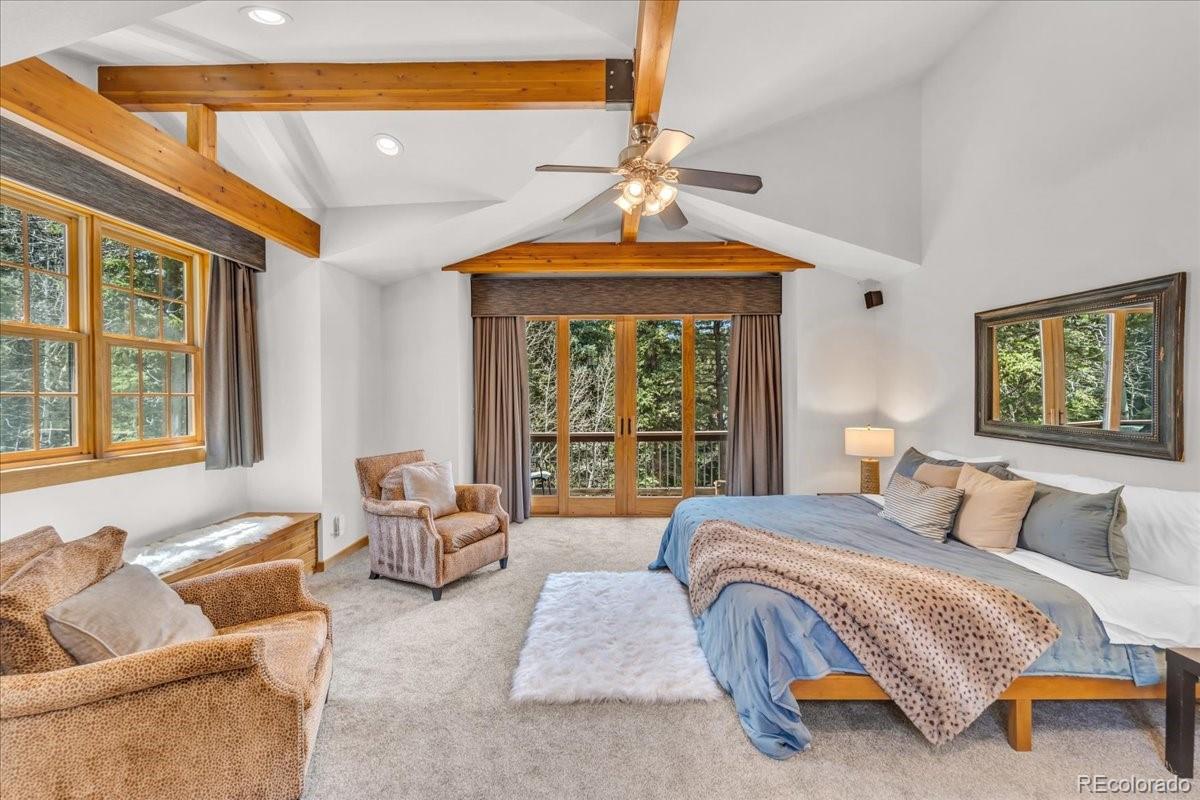 32217 Buffalo Park Road Evergreen, CO 80439 - Photo 10 of 46 a bedroom with bed and glass window