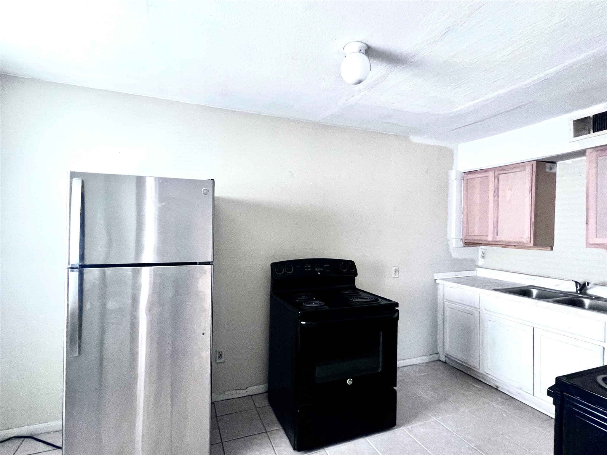 6802 Sayers Street, Unit A FEW Houston, TX 77016 - Photo 17 of 32 a kitchen with a refrigerator and cabinets