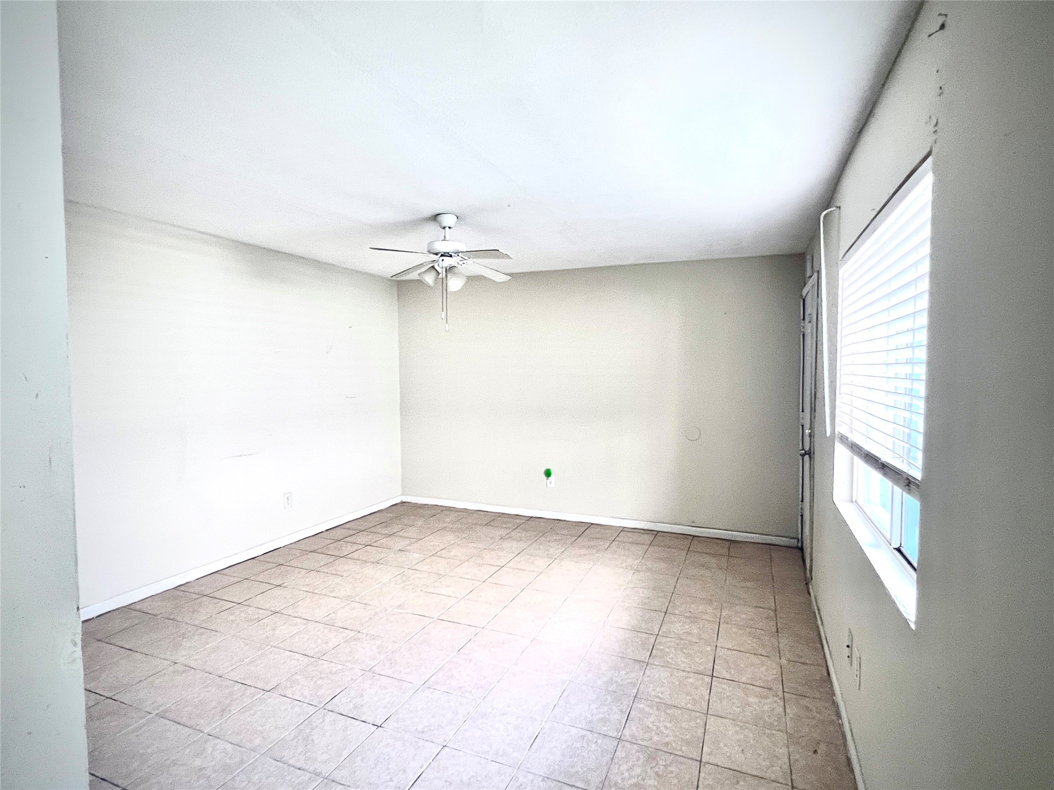 6802 Sayers Street, Unit A FEW Houston, TX 77016 - Photo 9 of 32 an empty room with a chandelier fan and windows