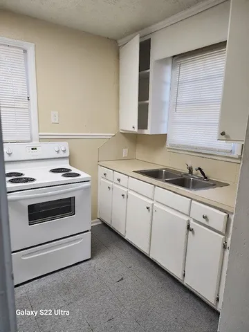 a kitchen with granite countertop white cabinets and white appliances