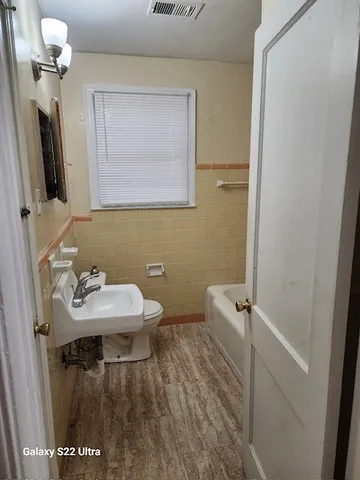 a bathroom with a sink a toilet and mirror