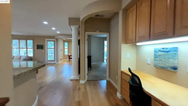 a view of a hallway with wooden floor and cabinet